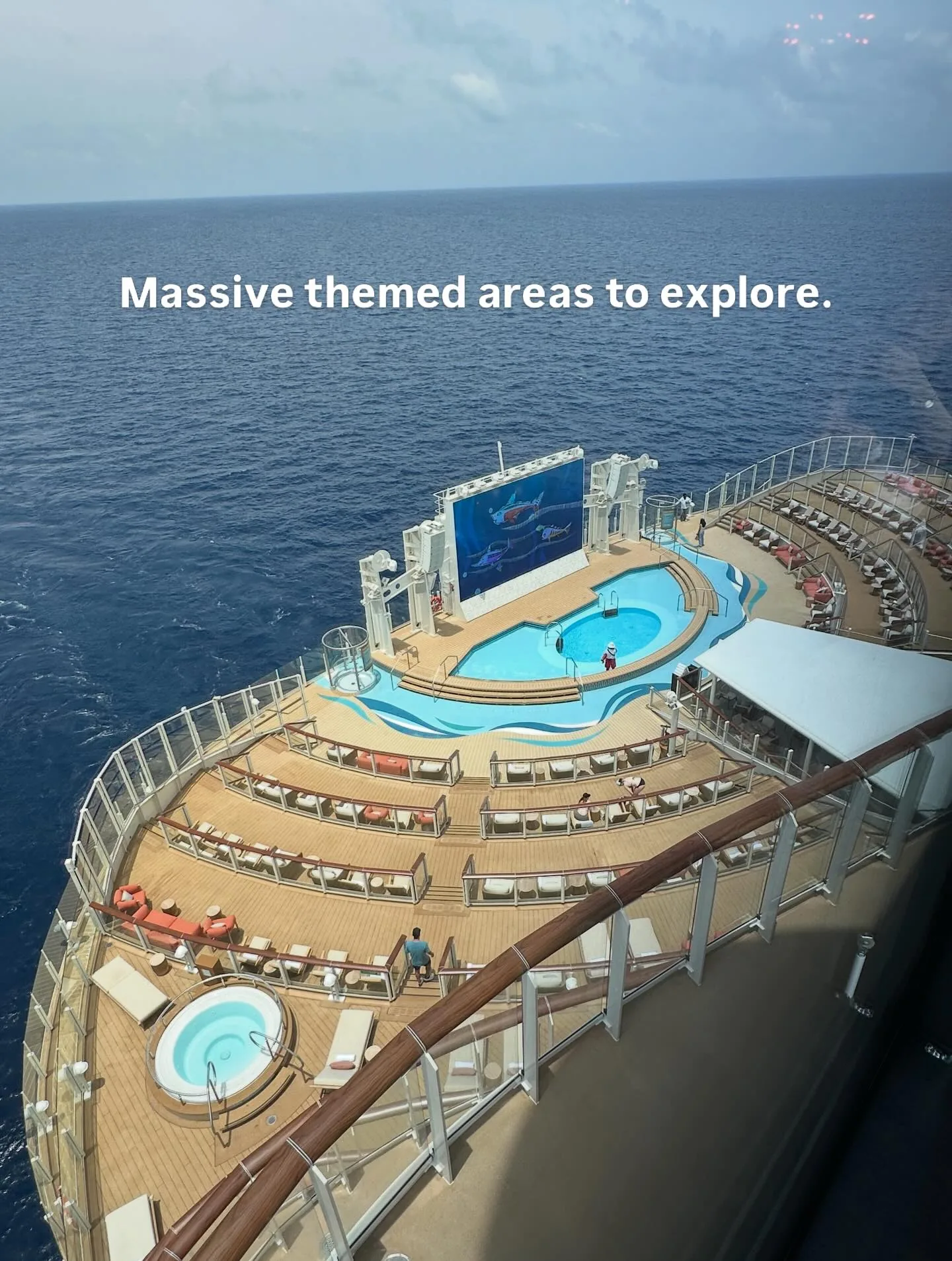 Wayfinder Bay pool deck aerial view on Disney Adventure with movie screen ocean loungers and hot tubs