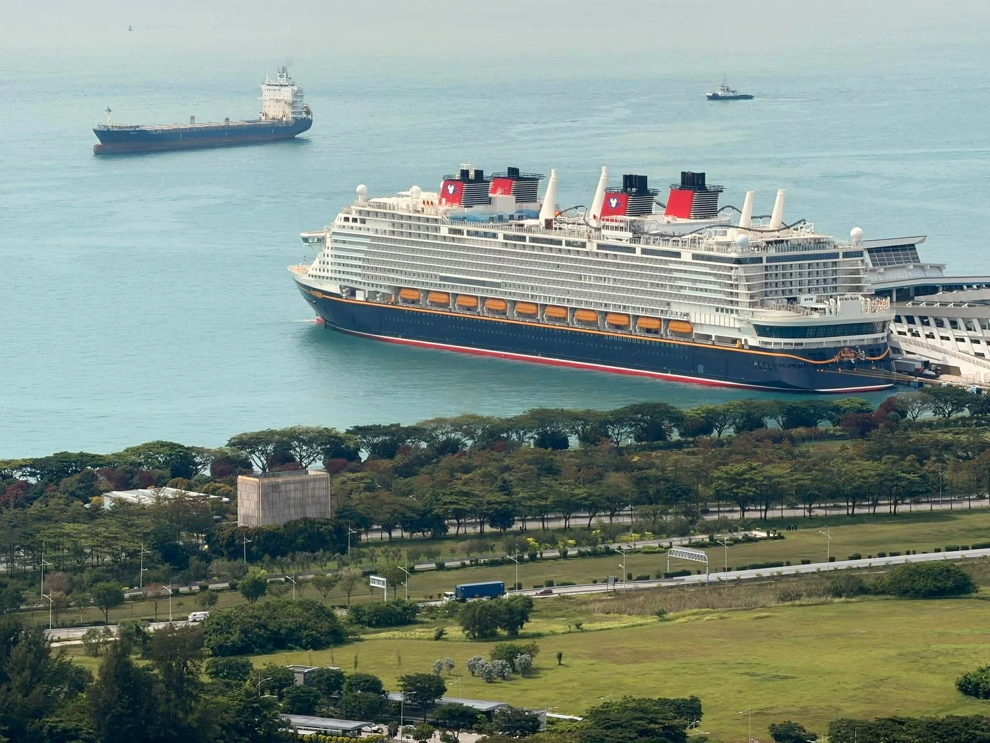 Disney Adventure cruise ship aerial daytime view docked at Marina Bay Singapore showing all four funnels