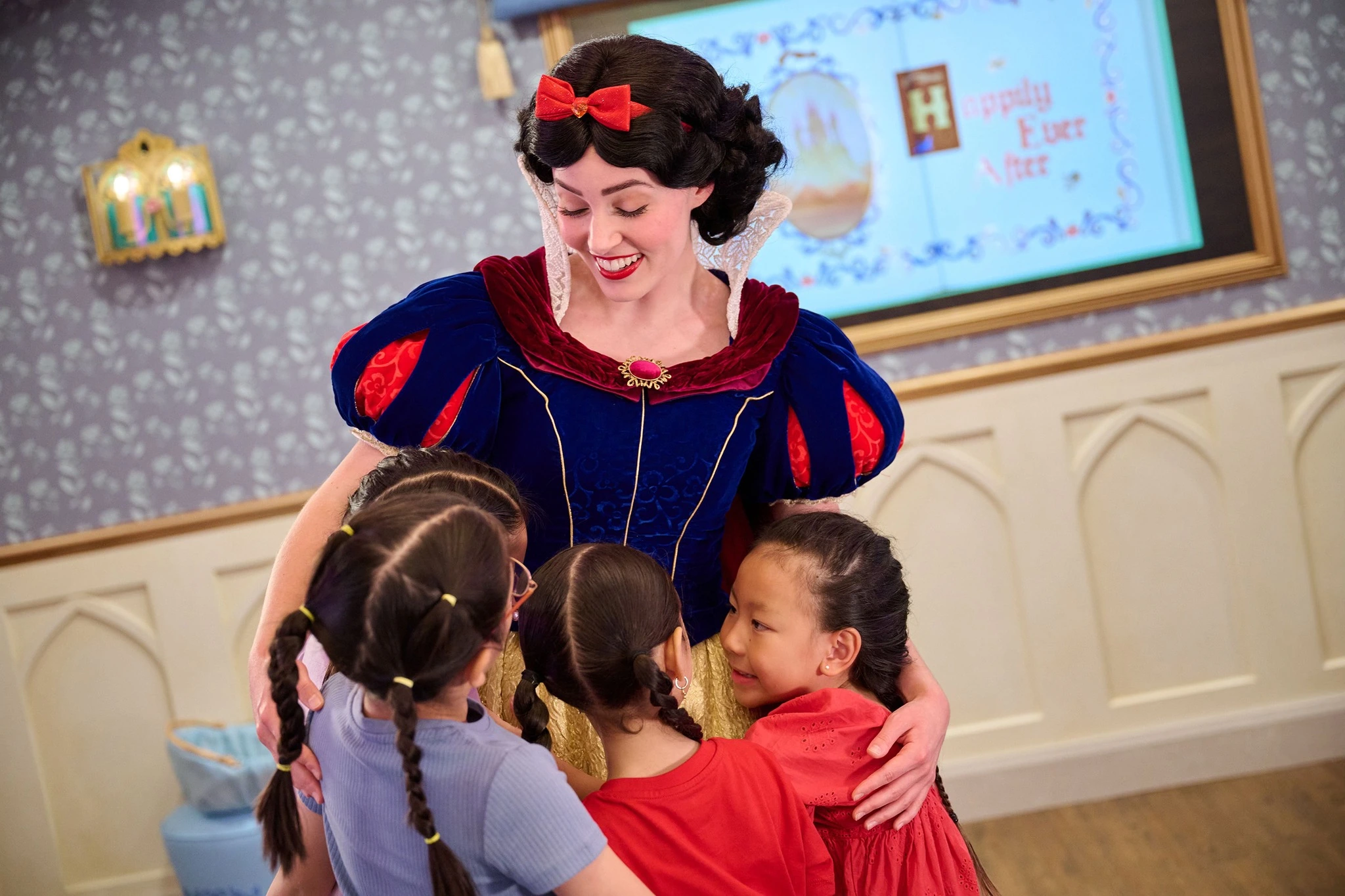 Snow White character hugging young children at Happily Ever After storytelling session on Disney Adventure