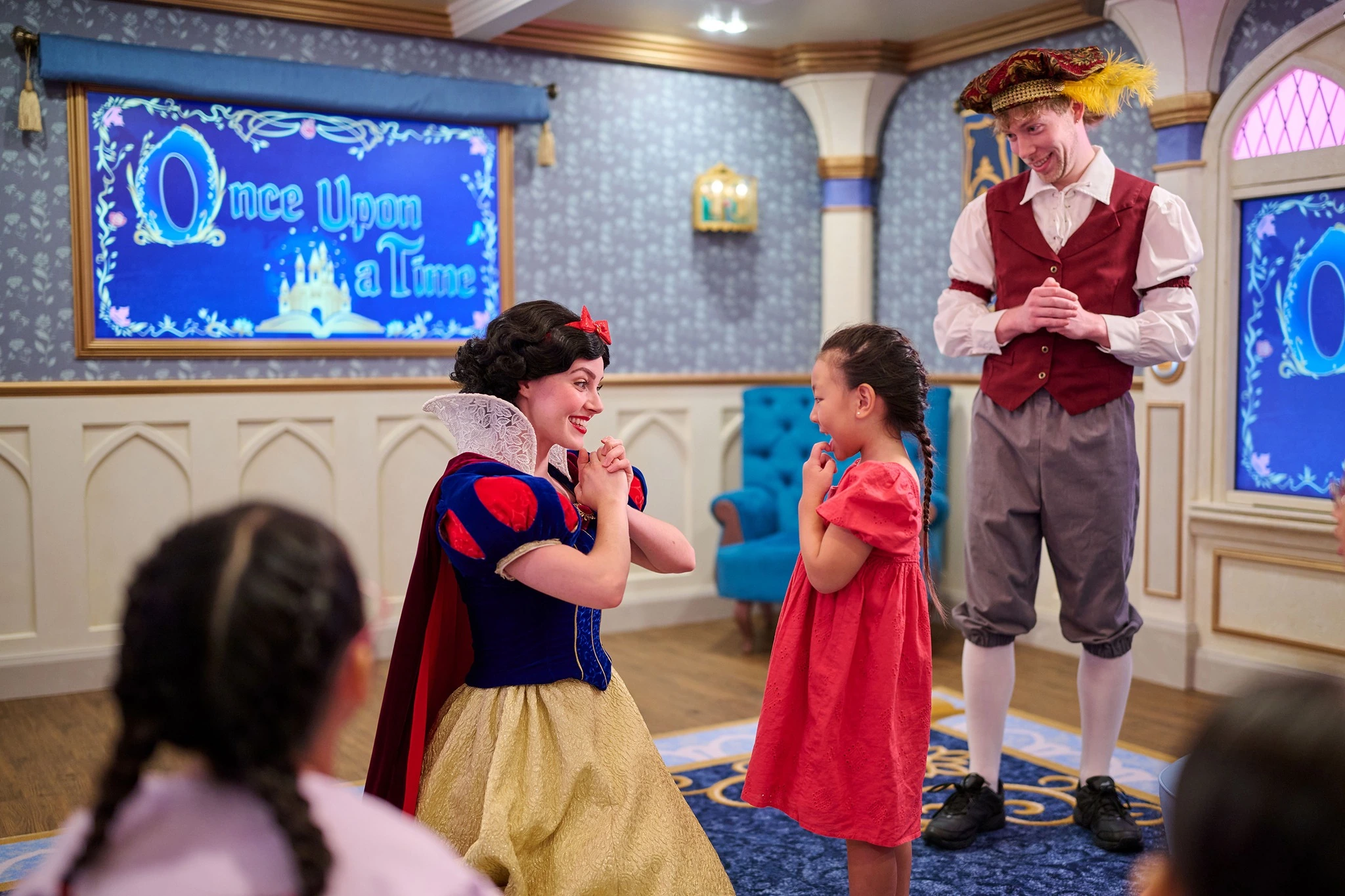 Snow White and Prince character interacting with excited young girl at Once Upon a Time experience on Disney Adventure