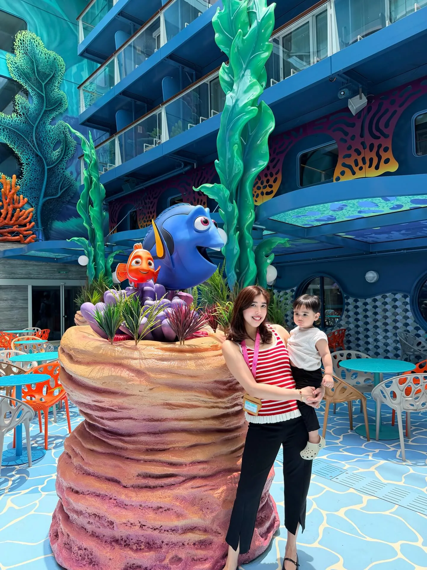 Nemo and Dory statue at Disney Discovery Reef area with colorful coral decor and balconies on Disney Adventure