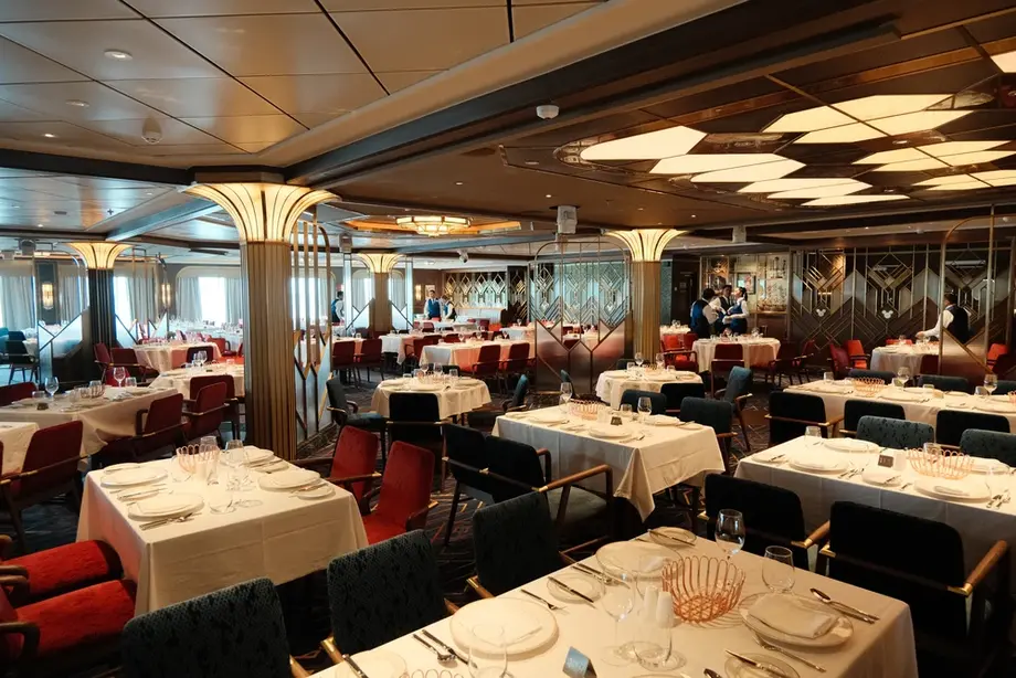 Navigator's Club rotational dining on the Disney Adventure — Art Deco interior with white tablecloths and velvet chairs